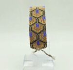 Bransoletka w stylu art-deco,wtszywana z koralikow szklanych,w gemetryczne wzory.Połączenie kolorów starego złota i żywych barw